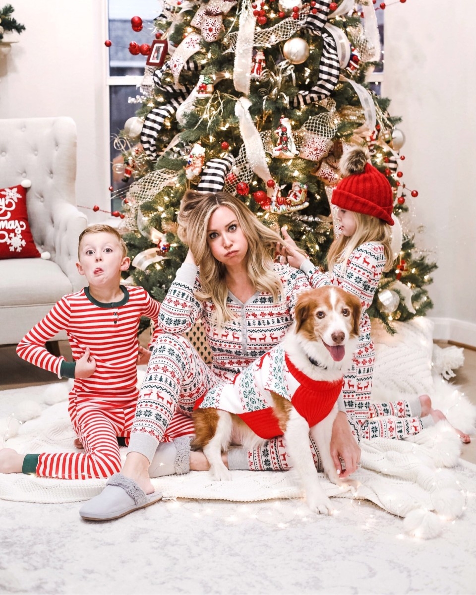 family christmas pajamas | Christmas Prep by popular Houston lifestyle blog: image of a woman and her son and daughter wearing family Christmas pajamas and sitting in front of a Christmas tree with their dog. 