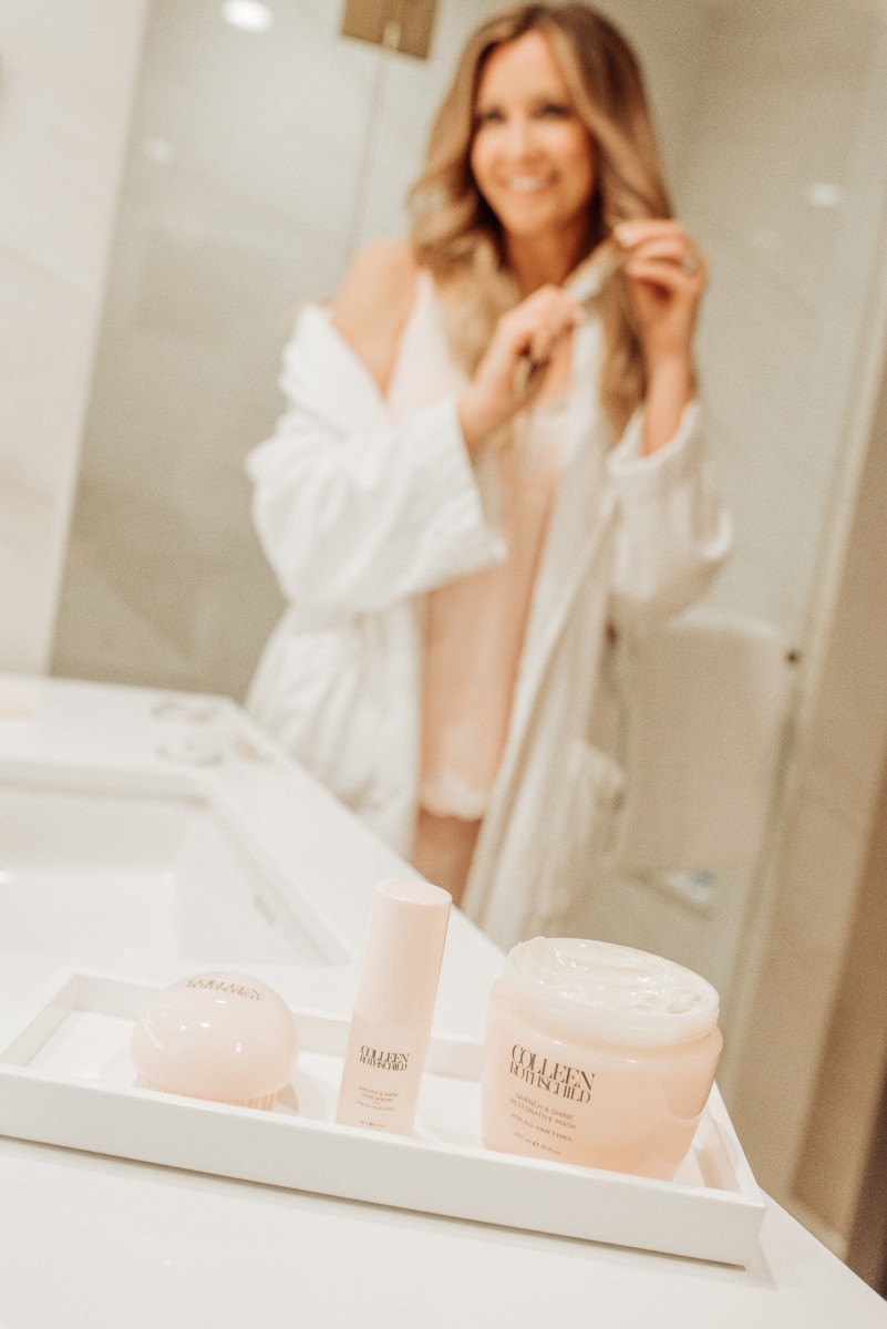 Healthy Shiny Hair featured by top US beauty blog Haute & Humid; Image of a woman in her bathroom.