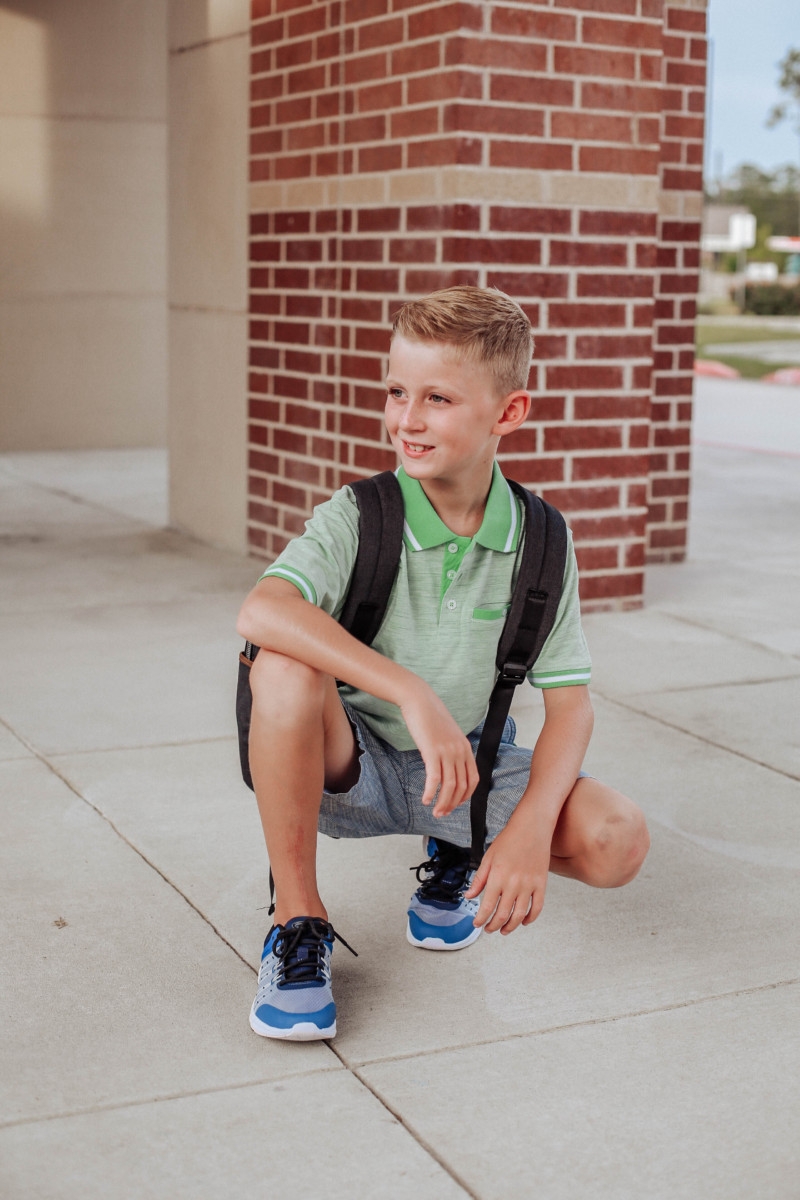 walmart back to school | Walmart Back To School Shopping by popular Florida fashion blog, Haute and Humid: image of boy standing in front of his school and wearing Walmart Athletic Works Boys' Slip On Cage Athletic Shoes, green Wonder Nation Short Sleeve Stretch Jersey Polo, and Wonder Nation Rib Waist Pull on Short.