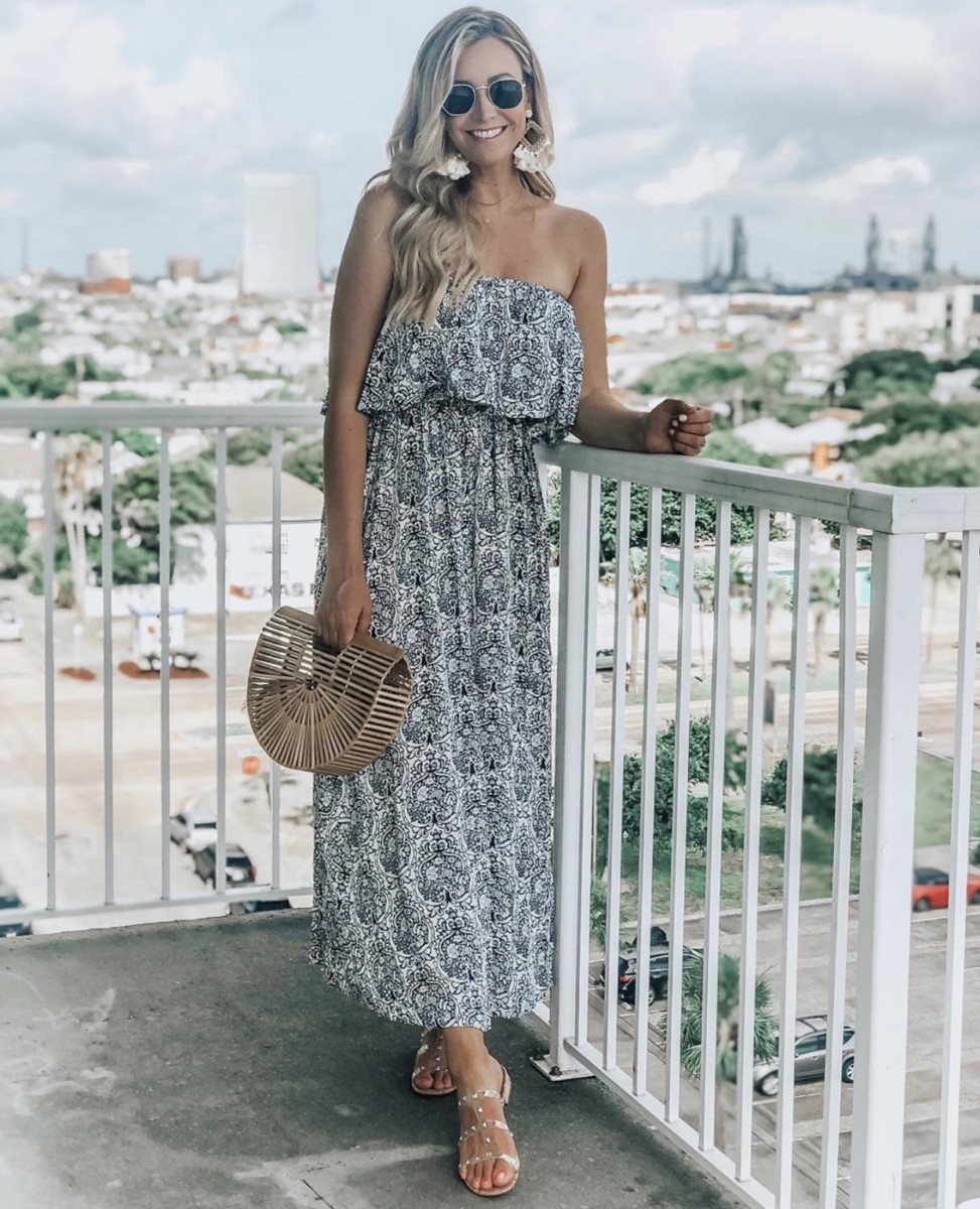 floral maxi dress | Amazon Prime Day 2019 by popular Houston life and style blog, Haute and Humid: image of a woman standing outside on a balcony and wearing a black and white Yidarton Women Summer Blue and White Porcelain Strapless Boho Maxi Long Dress.