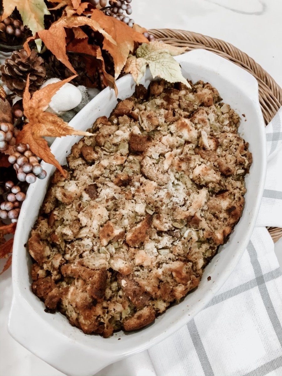 homemade stuffing | Ultimate Homemade Stuffing Recipe with Bread by popular Houston lifestyle blog, Haute and Humid: image of a white ceramic baking dish with homemade stuffing in it.