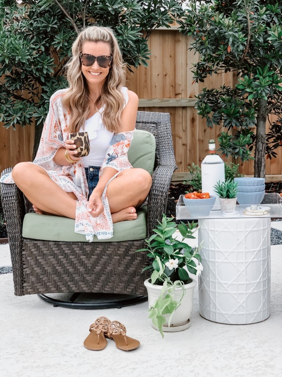 low calorie cocktails | Low Calorie Cocktail Recipes by popular Houston lifestyle blog, Haute and Humid: image of a woman holding a Nordstrom Corkcicle glass and sitting in a patio chair next to a end table with some Anthropologie latte bowls and a Nordstrom Wine Chiller VINGLACÉ on it. 