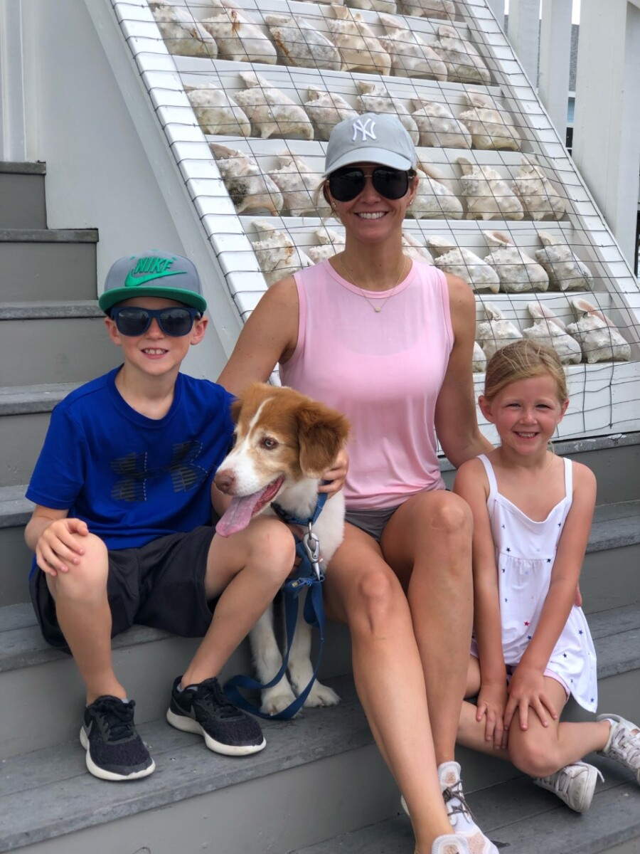 galveston travel guide | Galveston Travel Guide by popular Houston travel blog, Haute and Humid: image of a mom, her two kids, and a dog sitting on some steps outside next to a conch shell display. 
