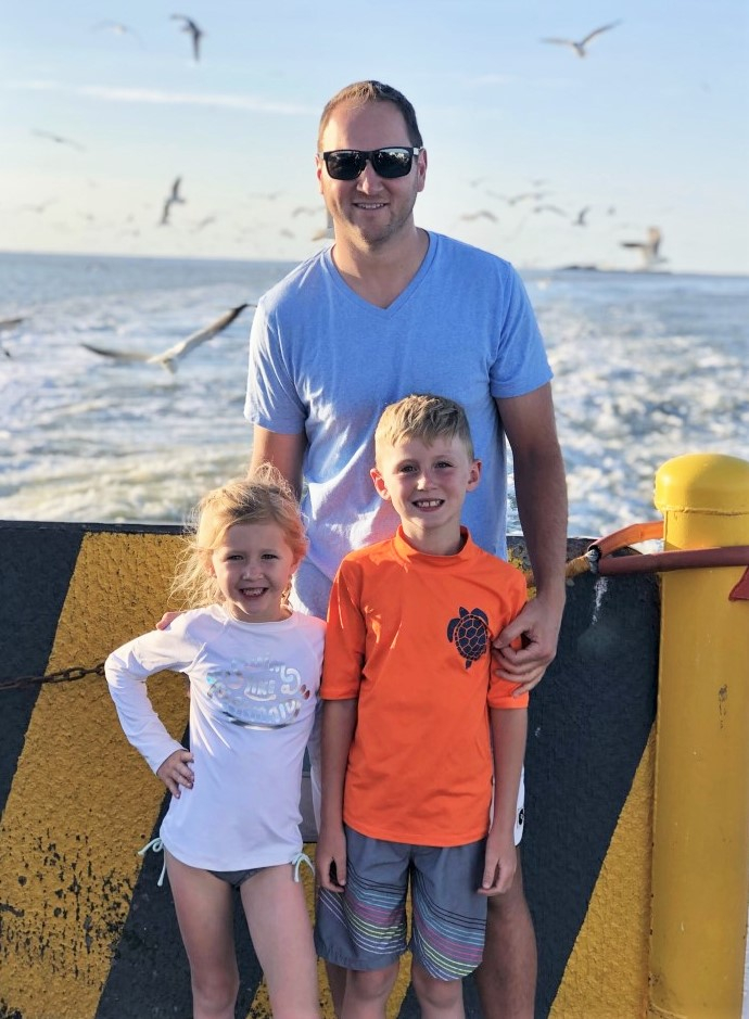 father's day gift guide | Father' Day Gift Ideas by popular Houston lifestyle blog, Haute and Humid: image of a dad standing with his son and daughter on a ferry. 