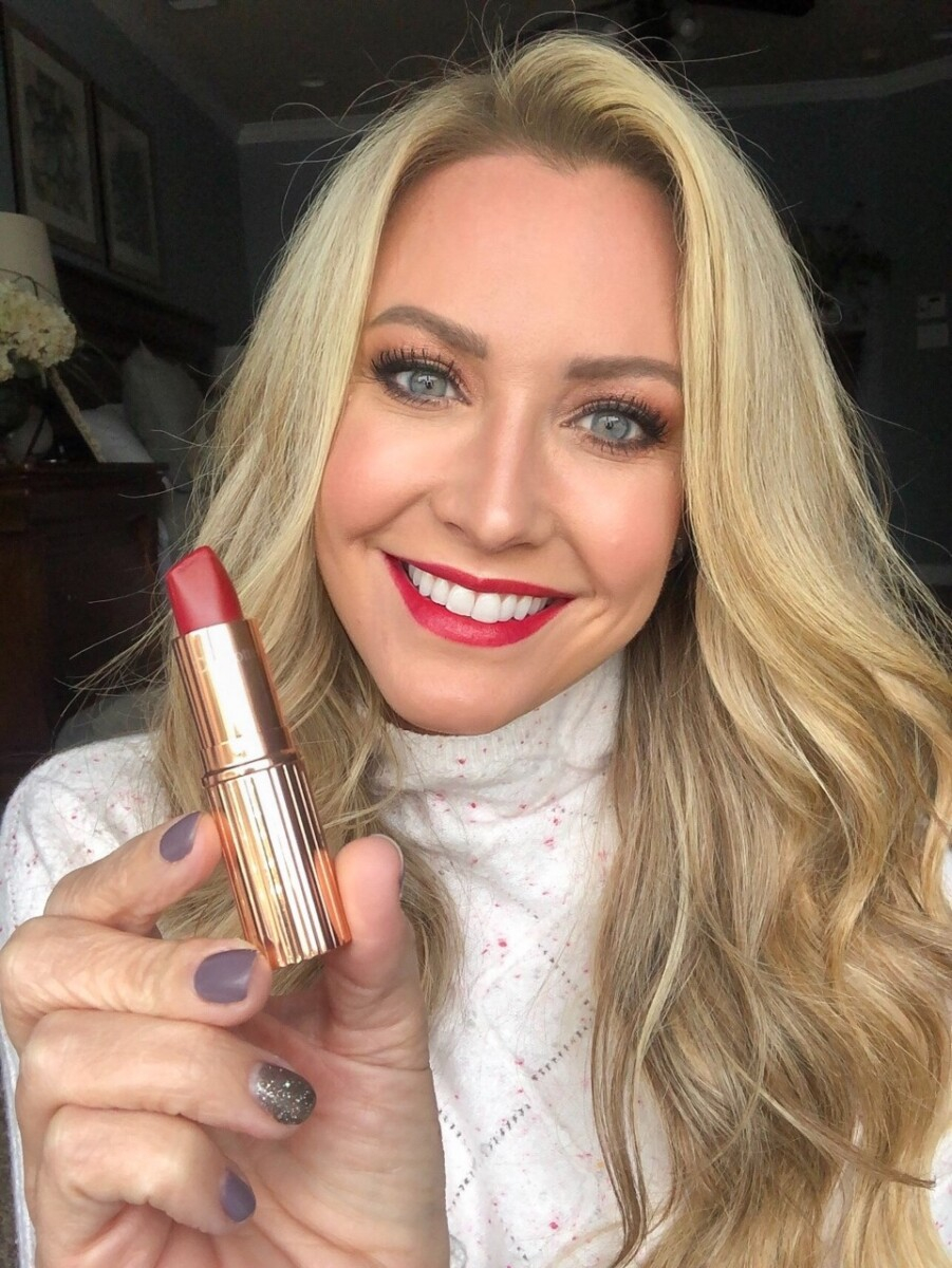 red lipstick |Stocking Stuffer Ideas by popular Houston life and style blog, Haute and Humid: image of a woman holding a tube of red lipstick. 