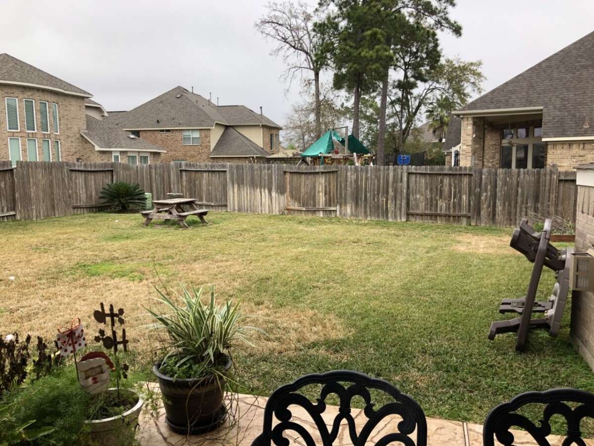 pool before and after | Outdoor Kitchen by popular Houston life and style blog, Haute and Humid: image of a backyard with grass, wooden picnic table, and wooden fence. 