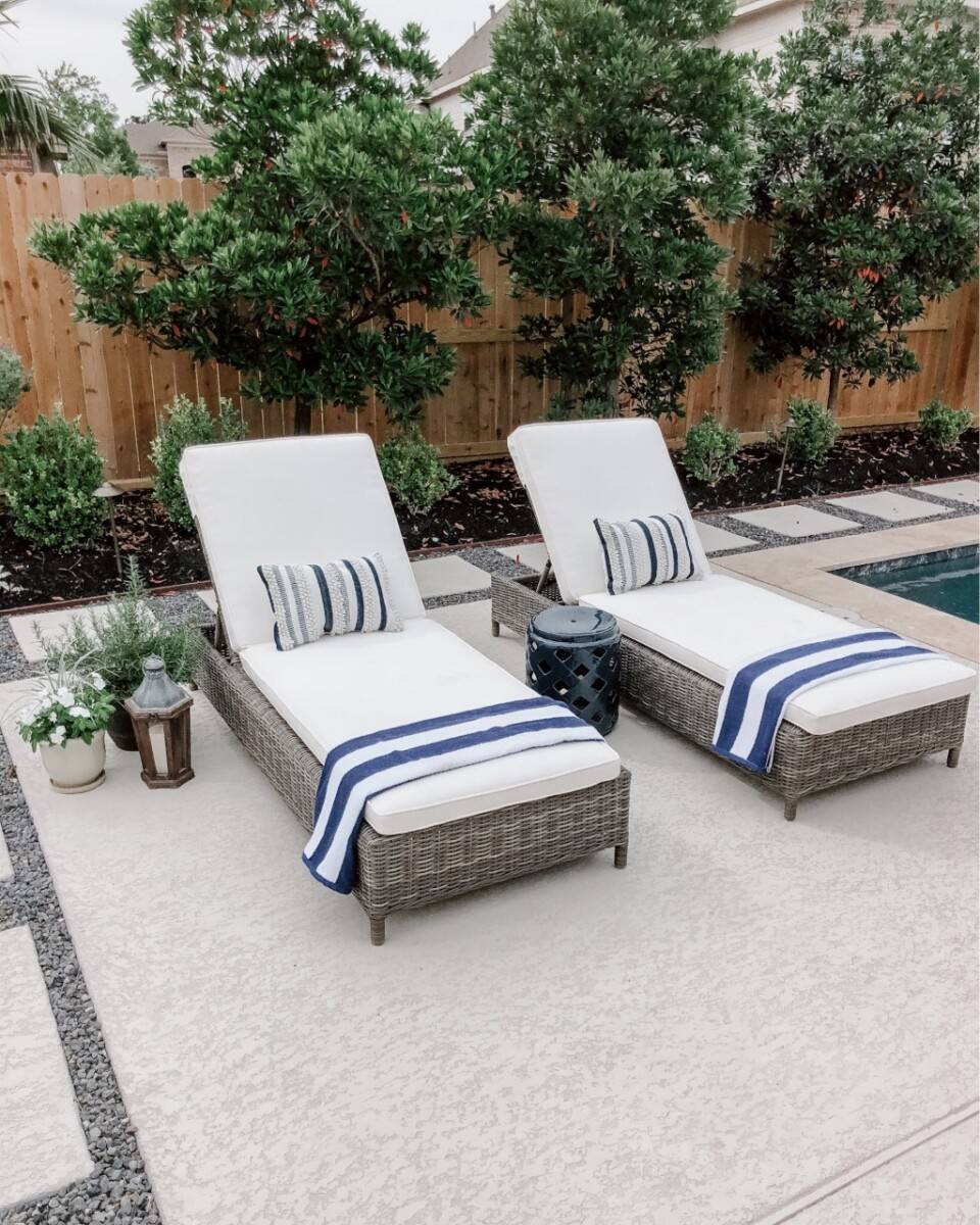 pool chaise lounge | Outdoor Kitchen by popular Houston life and style blog, Haute and Humid: image of two chaise lounge chairs with cream cushions and blue and white stripe towels. 