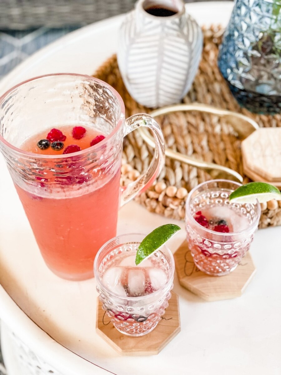 beer punch | Pitcher Cocktails by popular Houston lifestyle blog, Haute and Humid: image of beer punch in a tall glass pitcher and next to two clear glass hobnail tumbler glasses with lime wedges on Octagon shaped wooden coasters. 