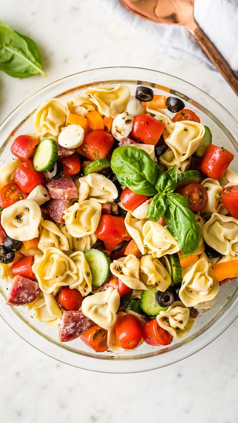 pasta salad | Summer Side Dishes by popular Houston lifestyle blog, Haute and Humid: image of cheesy tortellini pasta salad in a clear glass bowl.