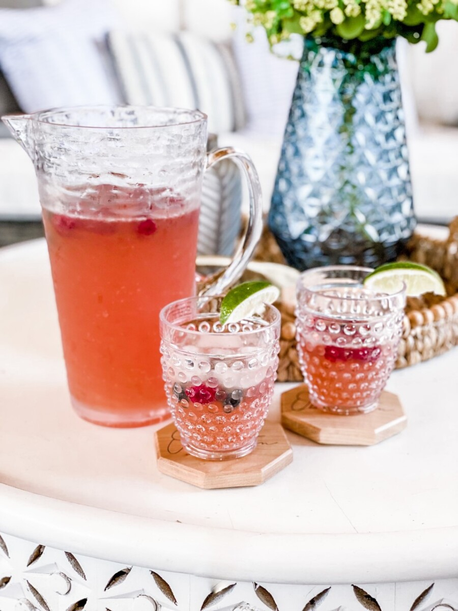 summer beer | Pitcher Cocktails by popular Houston lifestyle blog, Haute and Humid: image of beer punch in a tall glass pitcher and next to two clear glass hobnail tumbler glasses with lime wedges on Octagon shaped wooden coasters. 