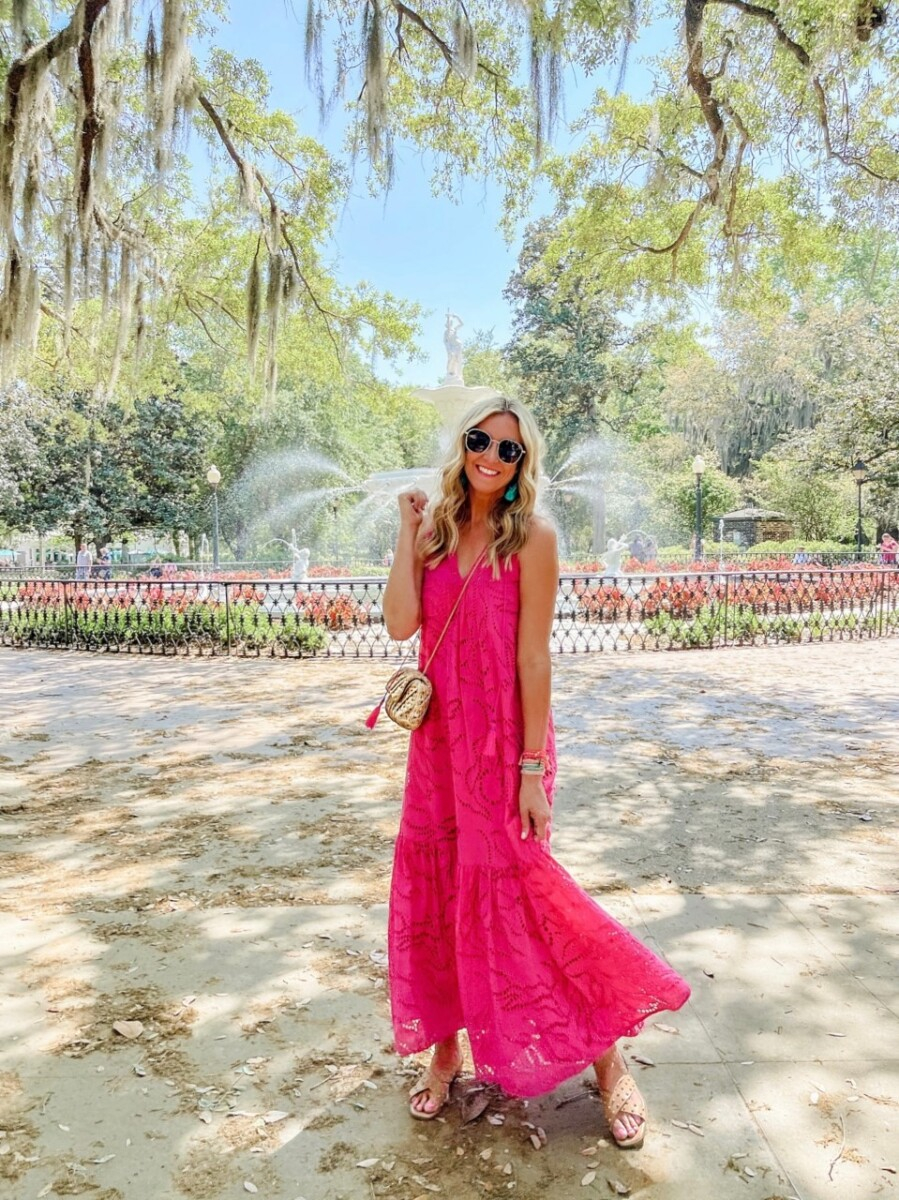 forsyth park | Savannah Georgia Travel Guide by popular Houston travel blog, Haute and Humid: image of woman standing infant of a fountain at Forsyth Park and wearing a pink maxi dress. 